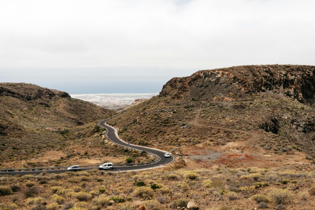 Beautiful curvy road through volcanic landscape in Canary Islands with ocean view.